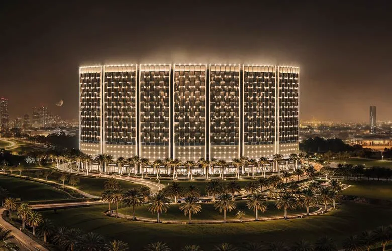 Illuminated contemporary residential building surrounded by palms at dusk